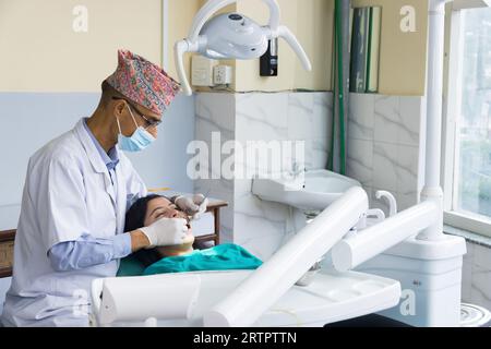 Katmandou, Népal - 02 septembre 2023 : Un dentiste népalais soignant son patient dans un hôpital dentaire Banque D'Images