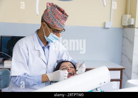 Katmandou, Népal - 02 septembre 2023 : Un dentiste népalais soignant son patient dans un hôpital dentaire Banque D'Images