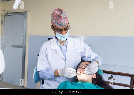 Katmandou, Népal - 02 septembre 2023 : Un dentiste népalais soignant son patient dans un hôpital dentaire Banque D'Images