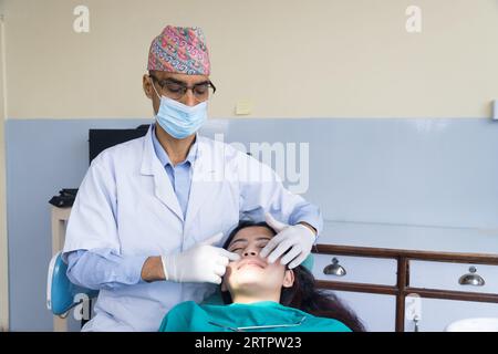 Katmandou, Népal - 02 septembre 2023 : Un dentiste népalais soignant son patient dans un hôpital dentaire Banque D'Images