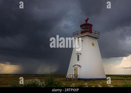 Phare du cap Egmont, Île-du-Prince-Édouard, Canada, Î.-P.-É., alors qu’un nuage de tempête s’approchait du détroit de Northumberland. Banque D'Images