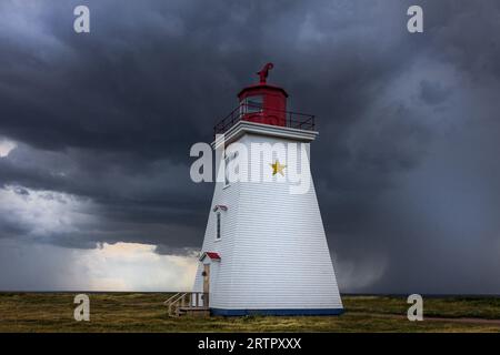 Phare du cap Egmont, Île-du-Prince-Édouard, Canada, Î.-P.-É., alors qu’un nuage de tempête s’approchait du détroit de Northumberland. Banque D'Images