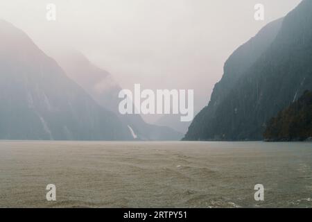 Photographie de nuages bas suspendus au-dessus des montagnes dans Milford Sound dans le parc national de Fiordland sur l'île du Sud de la Nouvelle-Zélande Banque D'Images