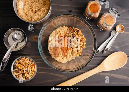 Préparation de la garniture pour Hotteok Sweet Korean Pancakes : cassonade, cannelle, muscade et noix dans un bol à mélanger en verre Banque D'Images