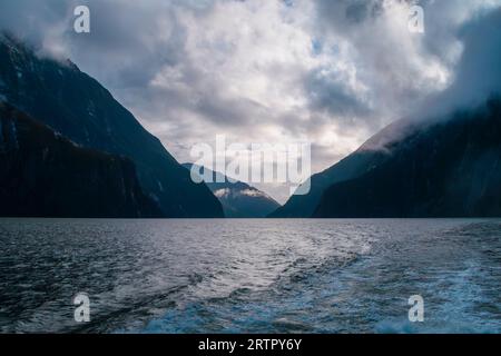Photographie de nuages bas suspendus au-dessus des montagnes dans Milford Sound dans le parc national de Fiordland sur l'île du Sud de la Nouvelle-Zélande Banque D'Images