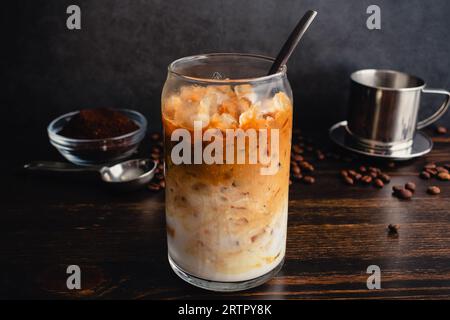 Café au yaourt vietnamien (Sua Chua Cafe ou Cà Phê Sữa) : un verre de café vietnamien glacé avec du yaourt filtré avec une cuillère et un filtre phin Banque D'Images