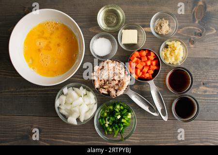 Ingrédients préparés pour le riz frit au crabe de style thaïlandais : ingrédients mesurés pour le riz frit aux fruits de mer dans des bols de préparation et des tasses à mesurer Banque D'Images