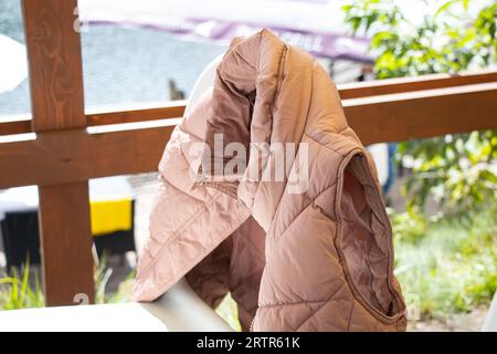 Gilet rose chaud pour femmes accroché sur une chaise dans la rue en Ukraine, mode et tendance Banque D'Images