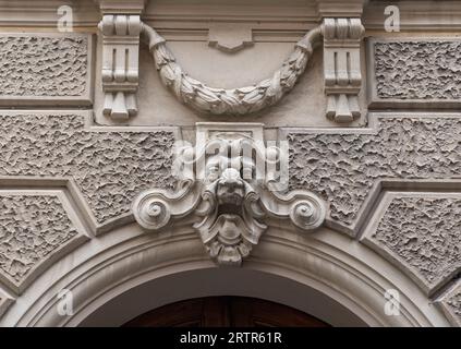 Détail de la porte supérieure d'un ancien palais décoré d'une sculpture représentant la tête d'un démon sous une couronne de Laurier, Italie Banque D'Images