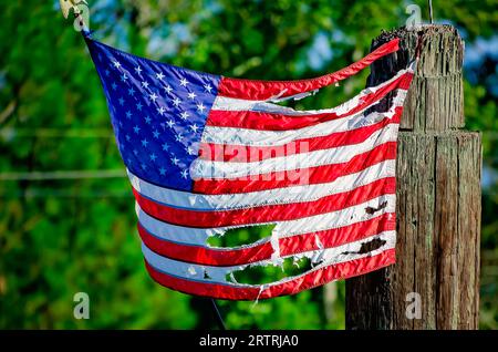 Un drapeau américain déchiré pend d'un poteau, le 11 septembre 2023, à Bayou la Batre, Alabama. Banque D'Images