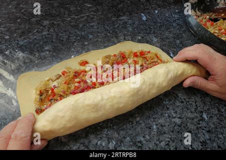 Cuisine souabe, préparation de copieux strudel de pommes de terre, pâte de pommes de terre crue garnie de légumes et de bacon coupé en dés, transformation, légumes rôtis Banque D'Images