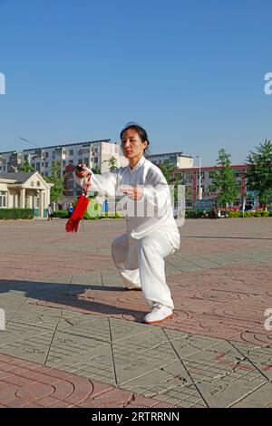 Comté de Luannan - 19 mai 2018 : une dame pratique l'épée de tai chi dans le parc, comté de Luannan, province du Hebei, Chine Banque D'Images