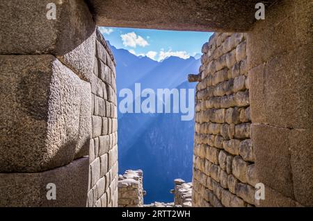 Vue sur les montagnes andines à travers la porte d'une maison dans la ville perdue Inca Machu Picchu Banque D'Images