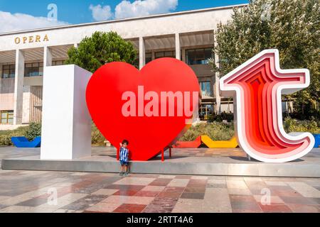 Portrait d'un enfant dans la sculpture I Love Tirana sur la place Skanderbeg à Tirana reflété. Albanie Banque D'Images