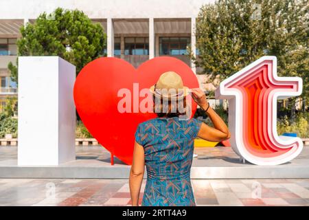 Une touriste féminine à la sculpture I Love Tirana sur la place Skanderbeg à Tirana a réfléchi. Albanie Banque D'Images