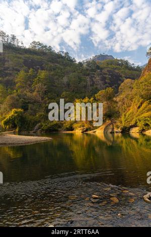 L'eau verte émeraude de la rivière Nine Bend ou de la rivière Jiuxi à travers Wuyishan ou le mont wuyi région pittoresque dans la province de Fujian en Chine. Arrière-plan du coucher du soleil Banque D'Images