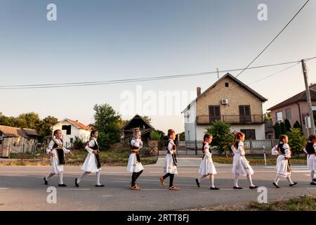 Photo d'un groupe d'enfants, d'enfants, de gens dansant un kolo serbe dans le village de Pecinci, en Serbie. Kolo est une danse circulaire slave du Sud, trouvé uedn Banque D'Images