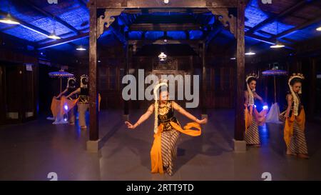 un groupe de danseurs sundanais avec du jasmin et des châles jaunes dansent sur scène la nuit Banque D'Images