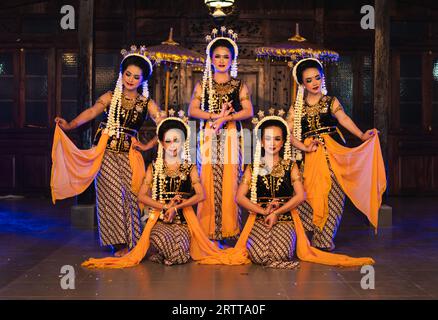 Un groupe de danseurs javanais pose en dansant avec leurs amis tout en prenant des photos sur scène la nuit Banque D'Images