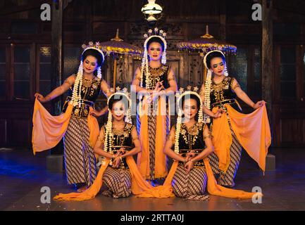 Un groupe de danseurs javanais pose en dansant avec leurs amis tout en prenant des photos sur scène la nuit Banque D'Images