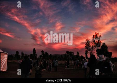 Les amateurs d'opéra profitent d'un ciel rose et bleu de nuages de cirrus, du crépuscule sur Uluru depuis l'arrière de la scène à Under the Outback Stars, première représentation de gala Banque D'Images