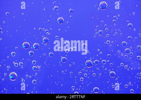 Fond de bulles d'eau. Macro bulles d'oxygène dans l'eau sur fond bleu. Banque D'Images