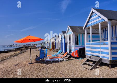 Southend-on-Sea : longue rangée de cabanes de plage colorées (boxes de bain), parasols et chaises à Southend-on-Sea, Angleterre, Royaume-Uni Banque D'Images