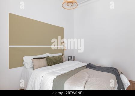 Lit minimaliste avec oreiller et couettes de couleur beige blanc dans une chambre au design moderne. Le concept d'un hôtel avec lits doubles. CopySpace Banque D'Images