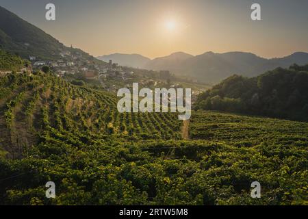 Vignobles et village Santo Stefano dans les collines de Prosecco au lever du soleil. Site du patrimoine mondial de l'UNESCO. Valdobbiadene, province de Trévise, région de Vénétie, Italie Banque D'Images