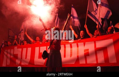 Les manifestants ont déclenché une éruption de fumée rouge alors que des milliers de manifestants antigouvernementaux se rassemblent devant la Cour suprême israélienne pour protester contre le plan du système judiciaire du gouvernement de droite dure d'Israël avant l'audition des pétitions contre la norme de la raisonnabilité devant la haute Cour de justice demain, le 11 septembre, 2023 à Jérusalem, Israël. Banque D'Images