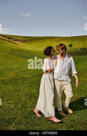 juste couple marié, mariée asiatique en robe blanche marchant avec le marié dans le champ, nature de campagne Banque D'Images