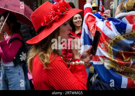 Une foule nombreuse descendait la rue Curzon sous la pluie pour observer le couronnement du roi Charles III. Curzon Street, Londres, Royaume-Uni. 6 mai 2023 Banque D'Images