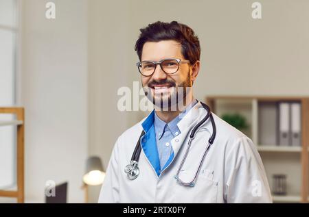 Portrait de médecin masculin joyeux en blouse de laboratoire blanche avec stéthoscope Banque D'Images