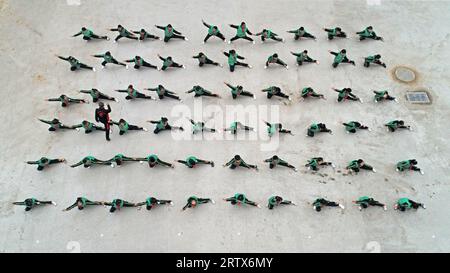 Les élèves du primaire pratiquent les compétences de base des arts martiaux traditionnels chinois sur le campus, dans le nord de la Chine Banque D'Images