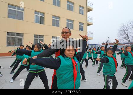 COMTÉ de LUANNAN, Chine - 9 décembre 2021 : les élèves du primaire pratiquent les compétences de base des arts martiaux traditionnels chinois sur le campus Banque D'Images