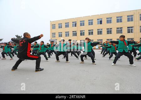 COMTÉ de LUANNAN, Chine - 9 décembre 2021 : les élèves du primaire pratiquent les compétences de base des arts martiaux traditionnels chinois sur le campus Banque D'Images