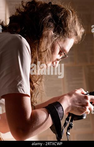 Profesional femme photographe tenant l'appareil photo et prenant des photos. Banque D'Images