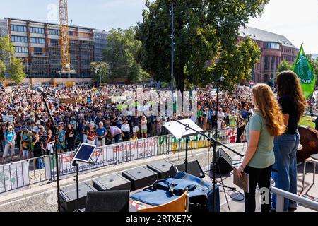 Freiburg im Breisgau, Allemagne. 15 septembre 2023. Des militants de l’organisation Fridays for future se tiennent sur scène lors d’une manifestation contre le changement climatique et pour la justice climatique sur la place de la Vieille Synagogue à Fribourg. Avec plus de 200 manifestations et rassemblements à travers l'Allemagne, le mouvement de protection du climat Fridays for future veut persuader le gouvernement d'accélérer l'élimination progressive du charbon, du pétrole et du gaz ce vendredi, dans le cadre de la grève mondiale sur le climat sous le slogan #EndFossilFuels. Crédit : Philipp von Ditfurth/dpa/Alamy Live News Banque D'Images