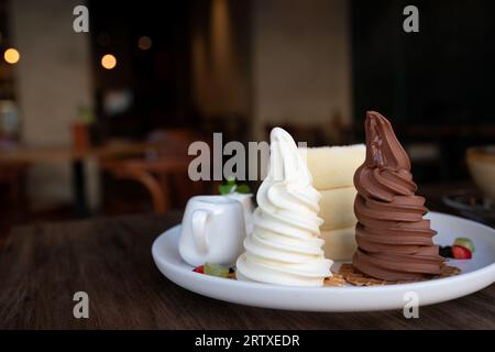 Gros plan crêpes soufflées avec dessert au chocolat et à la vanille servi avec sauce au miel. Banque D'Images