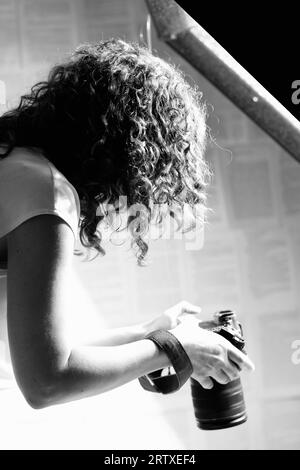 Profesional femme photographe tenant l'appareil photo et prenant des photos. Banque D'Images