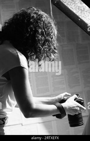 Profesional femme photographe tenant l'appareil photo et prenant des photos. Banque D'Images