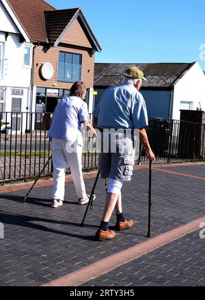 couple de personnes âgées marchant ensemble avec des bâtons de marche, littlehampton town, west sussex, uk septembre 14 2023 Banque D'Images