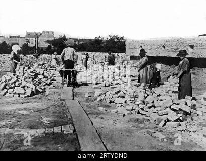 Berlin, Allemagne 1 novembre 1919 les citoyens allemands nettoient et empilent des briques prélevées sur les anciens forts pour être utilisées dans une nouvelle construction. Il y a une pénurie extrême de matériaux pour la construction dans l'Allemagne post-première Guerre mondiale. Banque D'Images