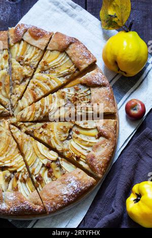 Tarte ouverte farcie de pommes, de coings et de noix sur fond de bois. Style rustique. Banque D'Images
