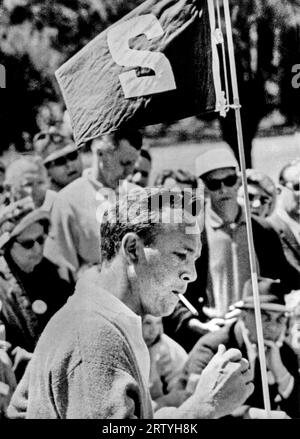 Augusta, Géorgie 8 avril 1961 le champion des Masters en titre, Arnold Palmer, souffle sur une cigarette alors qu'il se tient à côté du drapeau sur le deuxième green lors du deuxième tour. Banque D'Images