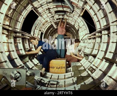 Long Beach, Californie octobre 1942 des travailleuses installent des accessoires et des assemblages sur une section de fuselage de queue d'un bombardier B-17 à l'usine Douglas Aircraft Company à long Beach, en Californie. Mieux connu sous le nom de « Forteresse volante », le B-17F est un modèle ultérieur du B-17. C'est un bombardier lourd à longue portée, à haute altitude, avec un équipage de sept à neuf hommes. Photographie prise par Alfred T. Palmer. Banque D'Images