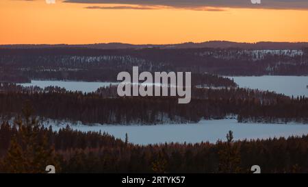 Paysage forestier d'hiver après le soleil s'est couché et coloré le paysage vu du sommet d'une colline en Finlande Banque D'Images