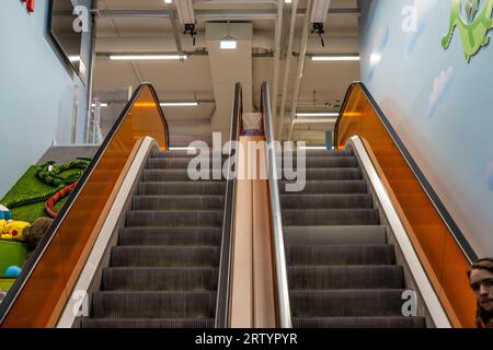 Dessus d'un escalier roulant avec des inserts de garde-corps en verre orange Banque D'Images