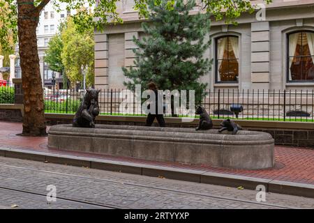 Femme marchant devant une fontaine avec un ours et deux oursons dans le centre-ville de Portland Oregon Banque D'Images
