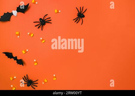 Décor Halloween sur fond orange, chauves-souris, araignées et canne à sucre Banque D'Images